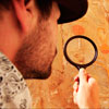 Archeologist inspecting wall inscription with magnifying glass