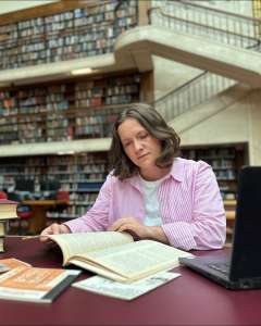 Jessica Urwin at the State Library of NSW reading a book