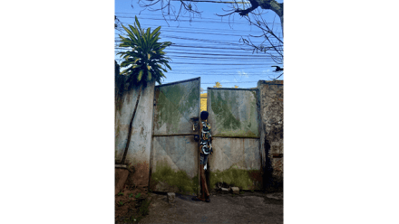 A child looks through a metalic door in Salvador di Bahia, Brazil
