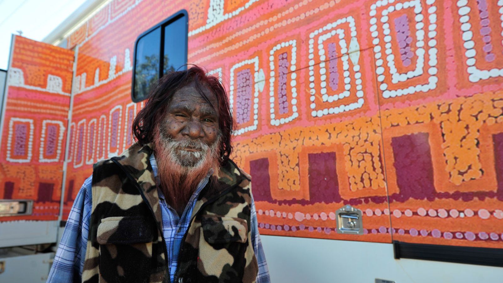  Patrick Tjungurrayi and his painting on the side of the Purple Truck.  Photo Courtesy Wayne Quilliam Photography. 
