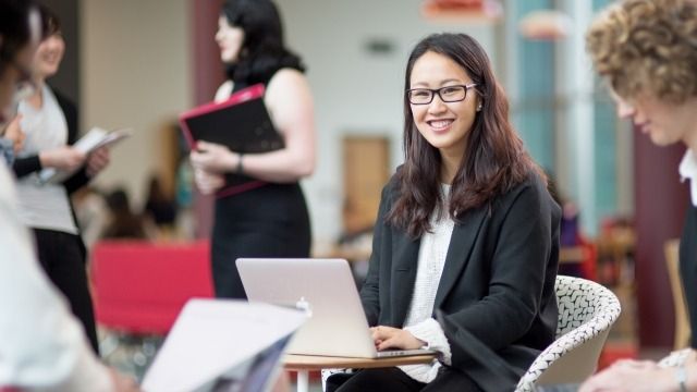 Girl sitting at table with laptop